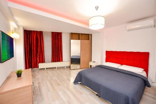 a bedroom with a large bed with a red headboard at Bucharest Accommodation Apartments in Bucharest