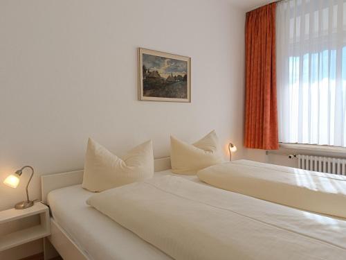two beds in a white room with a window at 2-Raum FeWo Hüttenzauber - Hallenbad & Sauna in Fischen