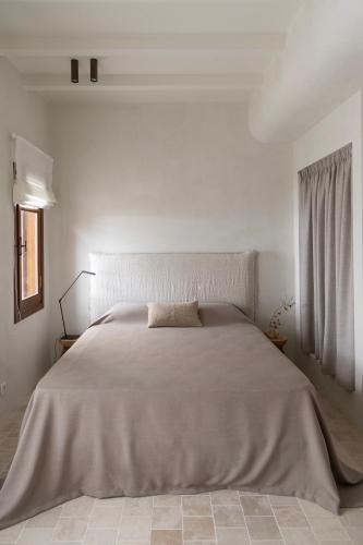 a white bedroom with a large bed in a room at Om Living Pelion in Agios Dimitrios