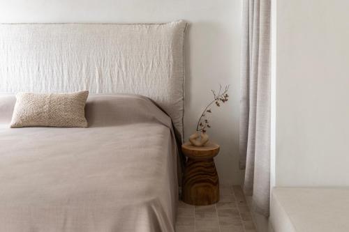 a bedroom with a bed with a pillow and a side table at Om Living Pelion in Agios Dimitrios
