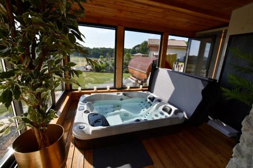 a jacuzzi tub on the deck of a house at Plaisir d'Eymet du Domaine des Hauts de Rouquette in Eymet
