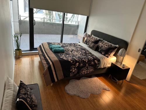 a bedroom with a bed and a large window at Stylish 1 bedroom best location in Sydney