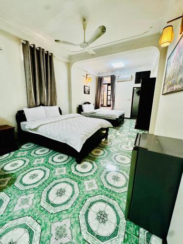 a hotel room with two beds and a green carpet at IL Divo Hostel & Spa Hàng Đào in Hanoi