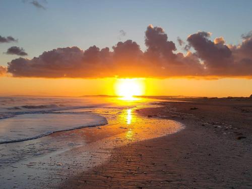 a sunset on a beach with the ocean at Charmant Studio Cabine 4 Pers, Balcons, Parking Privé, à 300m de la Plage de Merville-Franceville - FR-1-465-37 in Merville-Franceville-Plage