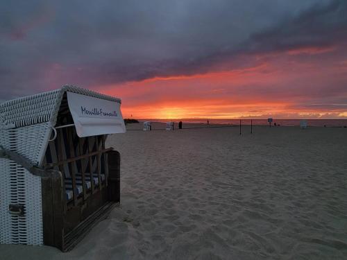 a sunset on a beach with a sign on it at Charmant Studio Cabine 4 Pers, Balcons, Parking Privé, à 300m de la Plage de Merville-Franceville - FR-1-465-37 in Merville-Franceville-Plage