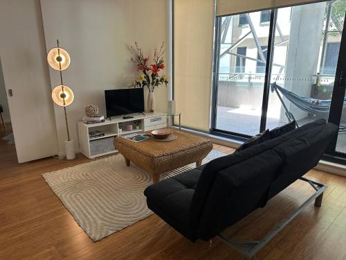 a living room with a couch and a table at Stylish 1 bedroom best location in Sydney
