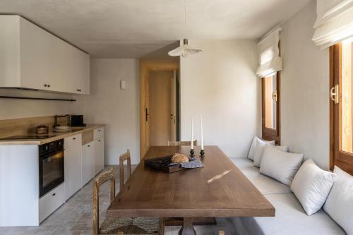 a kitchen and dining room with a wooden table at Om Living Pelion in Agios Dimitrios