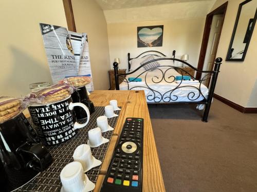 a table with two remote controls and a bed at The Kings Head inn in Addlethorpe