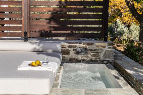 a bath tub with a bowl of fruit and a glass of water at Om Living Pelion in Agios Dimitrios