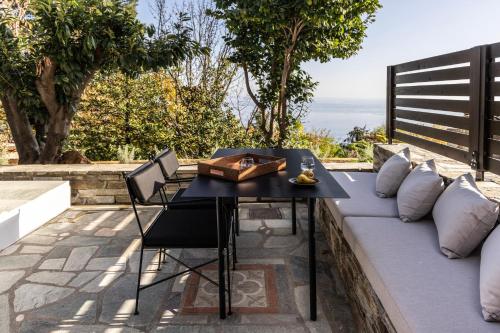 a table and chairs sitting on a couch on a patio at Om Living Pelion in Agios Dimitrios