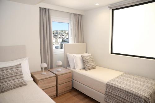 a bedroom with two beds and a window at Astric Seaview Penthouse in Athens
