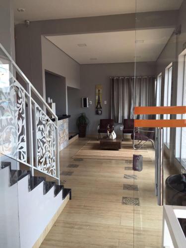 a living room with a staircase and a living room with a couch at Cerrado Gran Hotel in Rio Verde