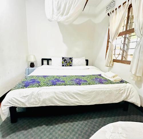 a bedroom with two beds and a window at Ethiopian restaurant and lodge in Arusha
