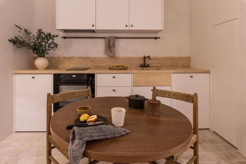 a kitchen with a wooden table with a plate of fruit on it at Om Living Pelion in Agios Dimitrios