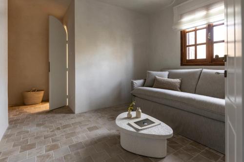a living room with a couch and a table at Om Living Pelion in Agios Dimitrios