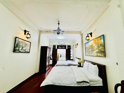 a bedroom with two beds and a chandelier at IL Divo Hostel & Spa Hàng Đào in Hanoi