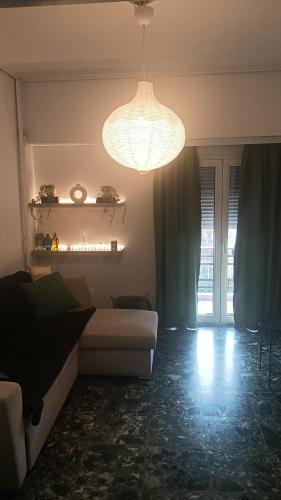 a living room with a couch and a chandelier at Mylos House in Tríkala