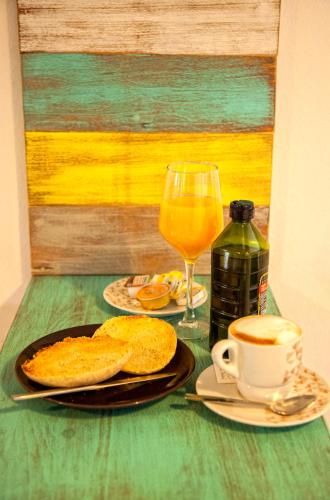 a table with a plate of food and a glass of orange juice at Hotel Posada de las Cuevas in Arcos de la Frontera
