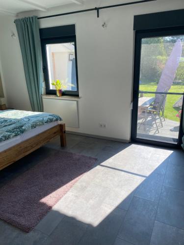 a bedroom with a bed and a window and a patio at Ferienhaus am Schwielochsee in Friedland