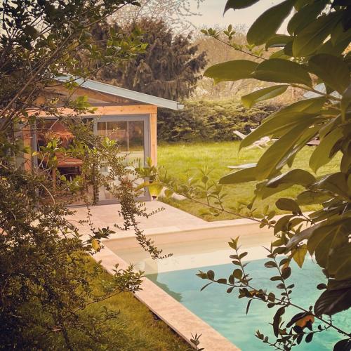 une maison avec une piscine dans un jardin dans l'établissement Cottage Normand avec sa grande piscine chauffée toute l année sur parc arboré et clos En plein coeur de la campagne adapté aux kids et Dog friendly, à Saint-Antonin-de-Sommaire