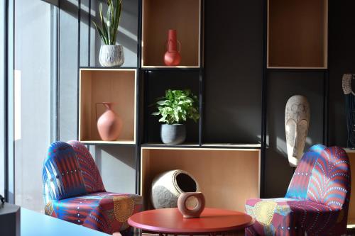 a living room with two chairs and a table at Ibis Styles Abidjan Plateau in Abidjan