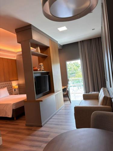 a hotel room with a bed and a tv at Hotel Equinocios Executive in Barcarena
