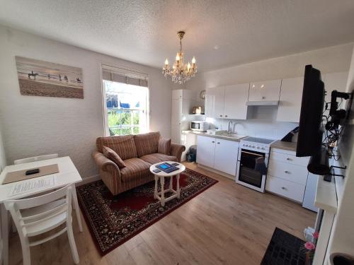 a living room with a couch and a table at The Studio Apartment in Weymouth
