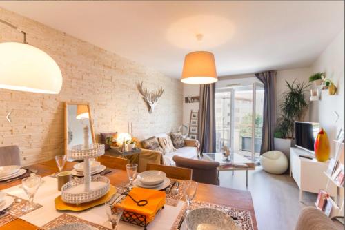 un salon avec un mur de briques dans l'établissement Petit Erdre - 2 chambres- gd appt ensoleillé- accès PMR, à Nantes