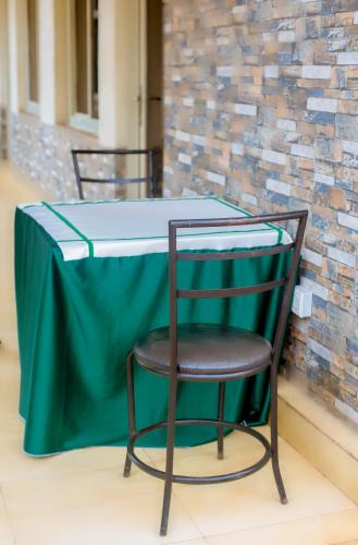 a table with a green table cloth and a chair at Martin Aviator Apartment in Kigali