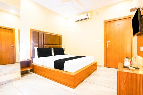 a bedroom with a bed with a wooden headboard at Townhouse Talwandi formerly Paras Royale in Kota