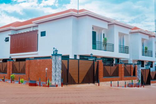 a white house with a gate and a fence at Martin Aviator Apartment in Kigali