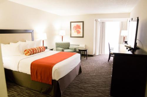 um quarto de hotel com uma cama e uma cadeira em Admiral Inn Hamilton em Hamilton