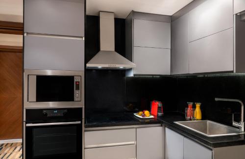 a kitchen with white cabinets and a stove top oven at Sofitel Cairo Downtown Nile in Cairo