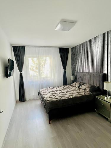 a bedroom with a large bed and a window at Gold House in Bucharest