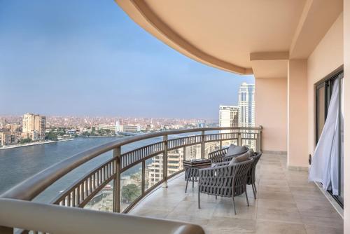 a balcony with chairs and a view of the water at Sofitel Cairo Downtown Nile in Cairo