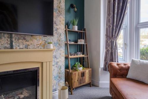 a living room with a fireplace and a couch and a television at Coastal 3-Bed with Great Rates for Long Stays in Cleethorpes