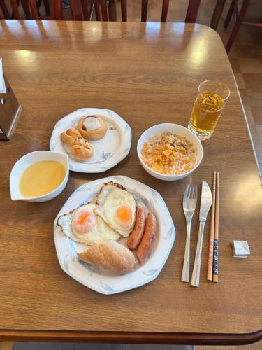 een tafel met twee borden met ontbijtproducten erop bij SamaSama Lodge Hakuba in Hakuba