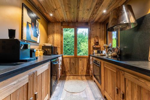 une cuisine avec des placards en bois et un grand comptoir dans l'établissement Chalet Le Petit Ramoneur, à Demi-Quartier