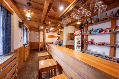 a bar in a restaurant with wooden tables and chairs at Horský hotel Kyčerka in Velké Karlovice