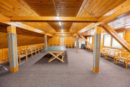 a room with a ping pong table and chairs at Horský hotel Kyčerka in Velké Karlovice