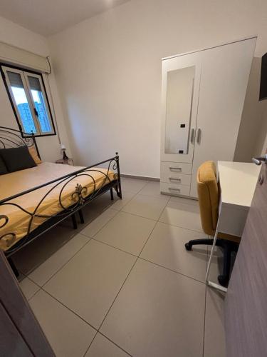 una stanza d'ospedale con un letto e una sedia di Casa Lele a Gela