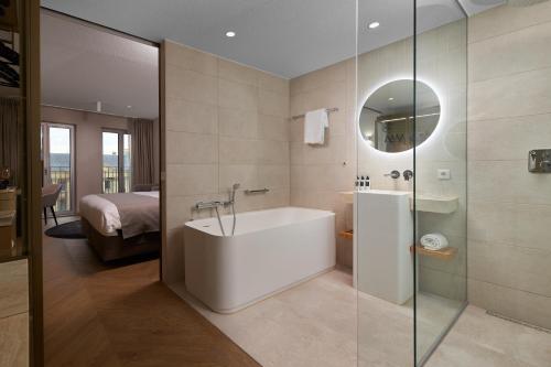 a bathroom with a tub and a glass shower at The Market Hotel in Groningen