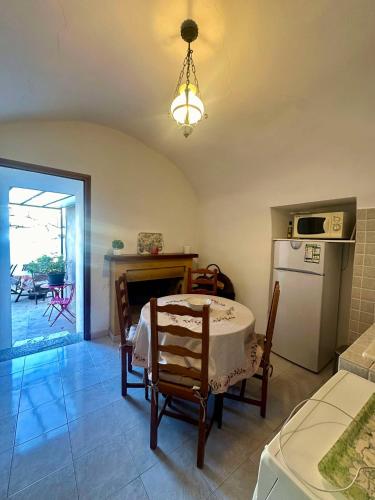 Il comprend un salon avec une table et une cuisine équipée d'un réfrigérateur. dans l'établissement Appartement au coeur de Lavatoggio, à Lavatoggio