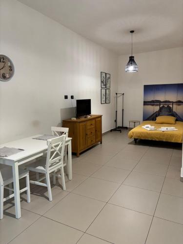 un soggiorno con un letto, un tavolo e delle sedie di Casa Lele a Gela