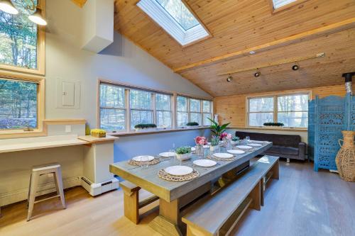 a large dining room with a long table and windows at Luxury Villa with Year Round Heated Pool, Sauna, Spa & Fire Pit - Newly Redone in East Stroudsburg