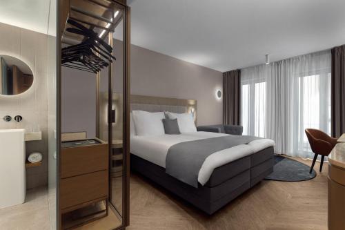 a hotel room with a bed and a mirror at The Market Hotel in Groningen