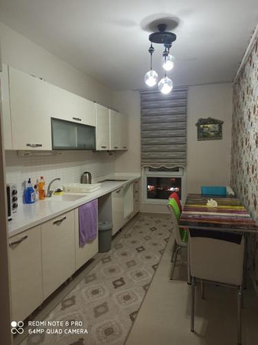 a kitchen with white cabinets and a table with chairs at ENTIRE 3 Bedroom Apartment with FREE PARKING in Esenyurt