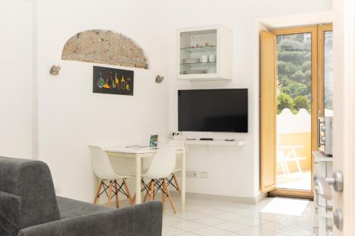 a living room with a table and a television at Coltur Suites in Sorrento