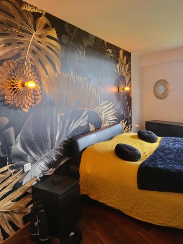 - une chambre avec un lit et un mur orné d'une fresque murale dans l'établissement villa pointe du raz, à Plouhinec