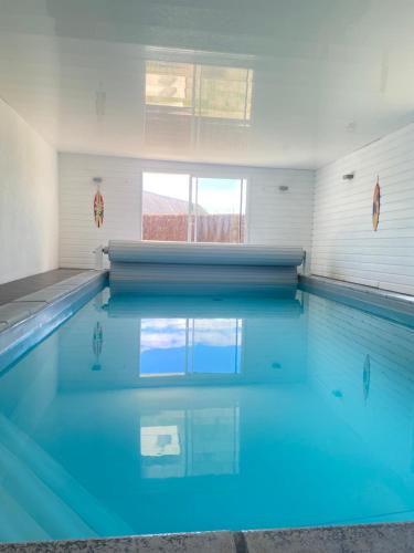une piscine avec de l'eau bleue dans un immeuble dans l'établissement villa pointe du raz, à Plouhinec